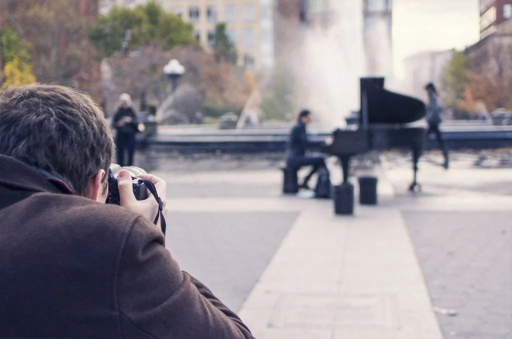 Fotograf fotografiert einen Pianisten bei einem Konzert unter freiem Himmel